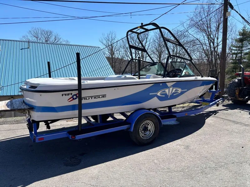 Slide: The Image of 2000 Nautique Air Nautique boat on trailer, blue and white design, parked outdoors. - 22