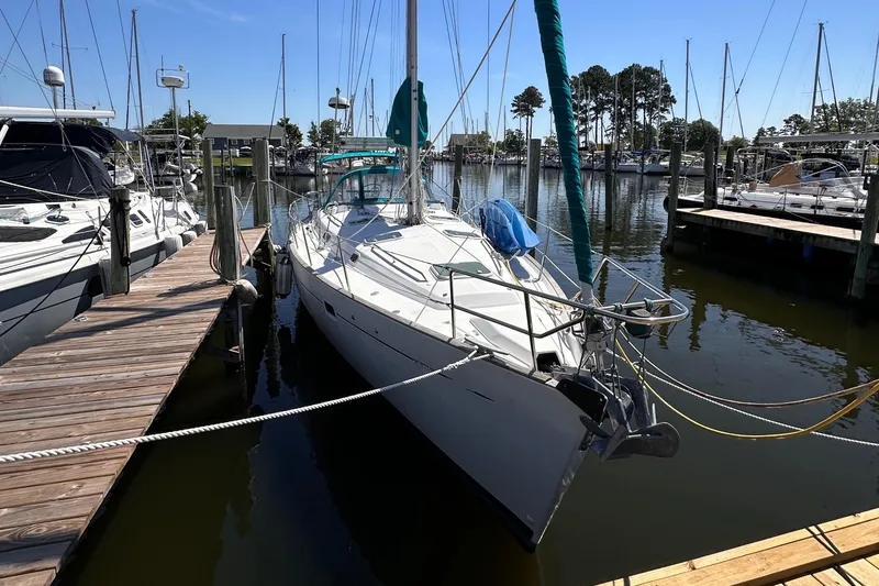 Slide: The Image of 2000 Beneteau 411 sailboat docked at marina, surrounded by other boats. - 10