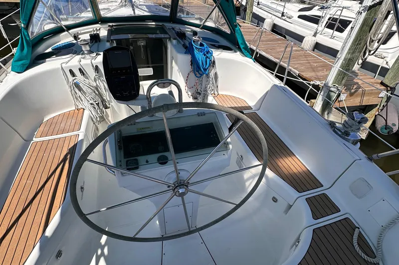 Slide: The Image of Cockpit of 2000 Beneteau 411 sailboat with teak flooring and large steering wheel. - 14