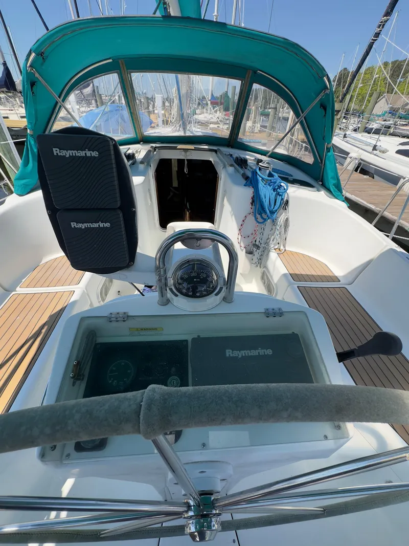 Slide: The Image of Cockpit of a 2000 Beneteau 411 sailboat with Raymarine equipment and teal canopy. - 15