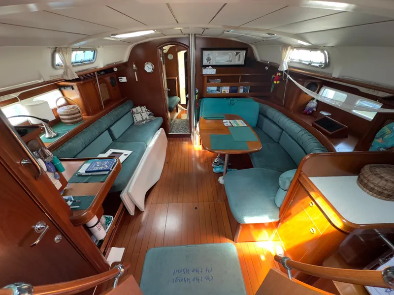 Slide: The Image of Interior of a 2000 Beneteau 411 sailboat with wood finish and teal seating. - 16