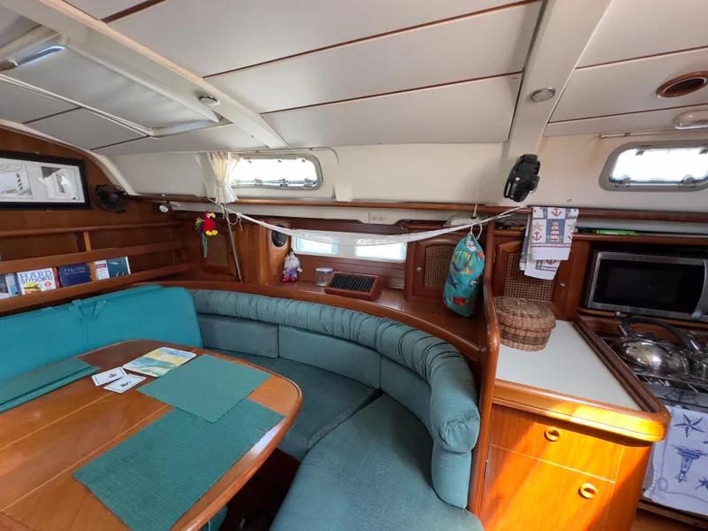 Slide: The Image of Interior of a 2000 Beneteau 411 sailboat with cozy seating and wooden finishes. - 18