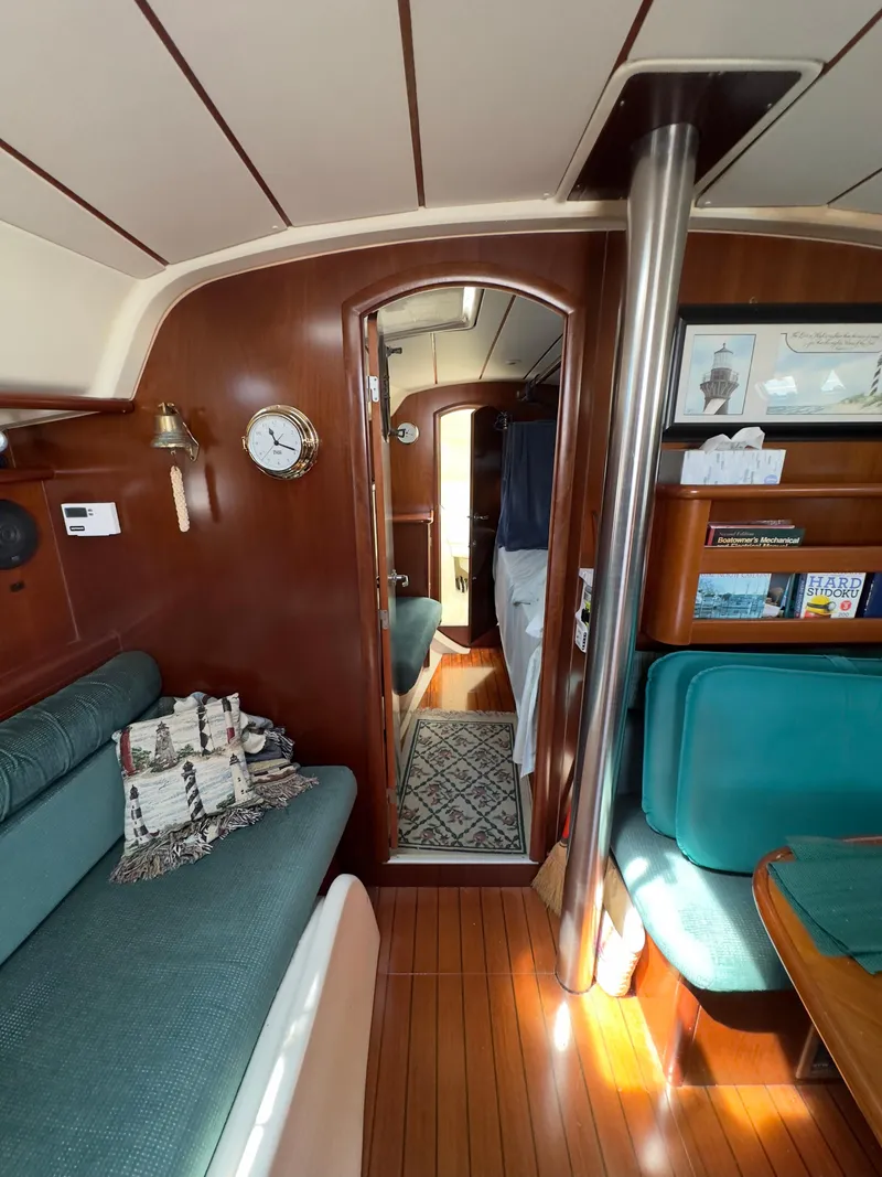 Slide: The Image of Interior of 2000 Beneteau 411 sailboat with wood paneling and teal seating. - 21