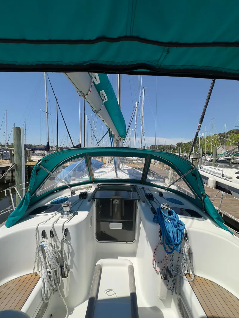 Slide: The Image of 2000 Beneteau 411 sailboat cockpit with green canopy, docked at marina. - 3
