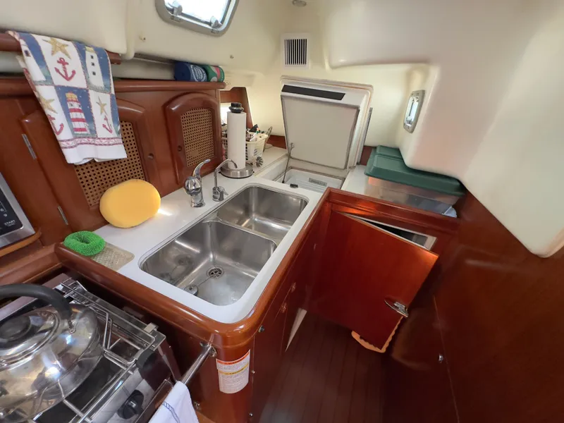 Slide: The Image of Interior of 2000 Beneteau 411 yacht kitchen with double sink and wooden cabinetry. - 33