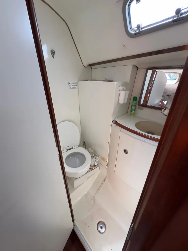 Slide: The Image of 2000 Beneteau 411 yacht bathroom with toilet, sink, and mirror. - 34