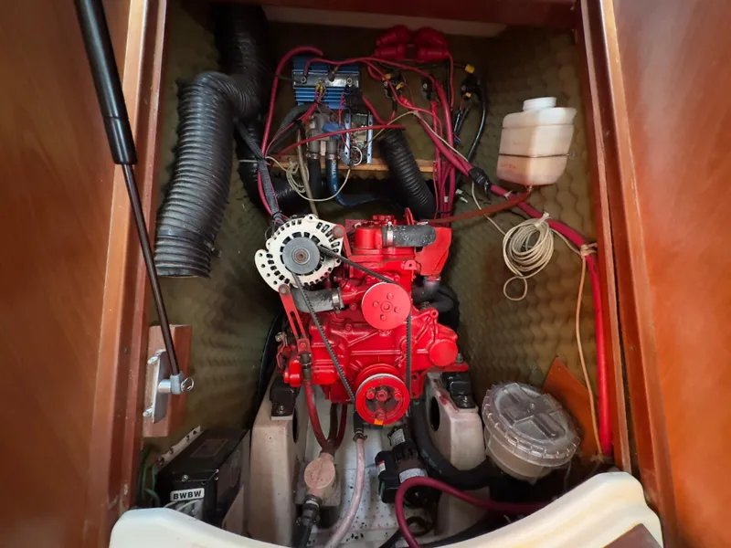 Slide: The Image of Engine compartment of a 2000 Beneteau 411 sailboat, showcasing mechanical components and wiring. - 39
