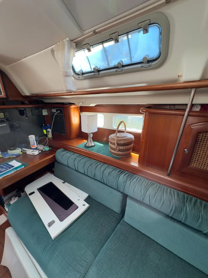 Slide: The Image of Interior of 2000 Beneteau 411 sailboat with cozy seating and wooden accents. - 40