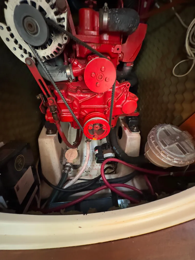 Slide: The Image of Engine compartment of a 2000 Beneteau 411 sailboat, featuring a red engine and wiring. - 42