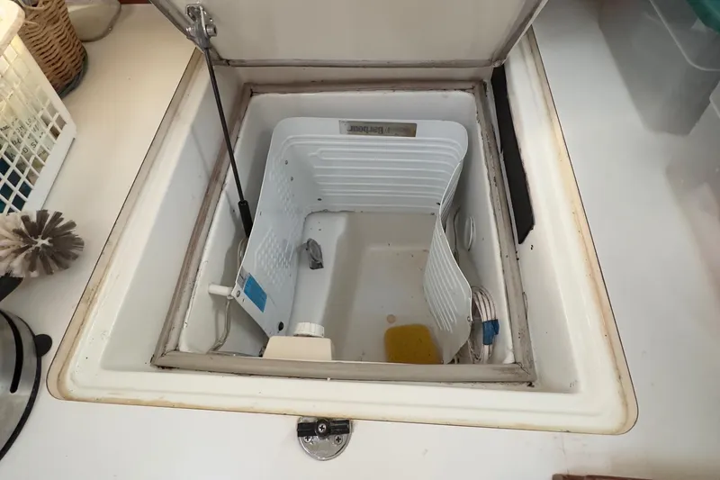Slide: The Image of Beneteau 411 (2000) boat interior storage compartment with open lid, showcasing spacious design. - 43