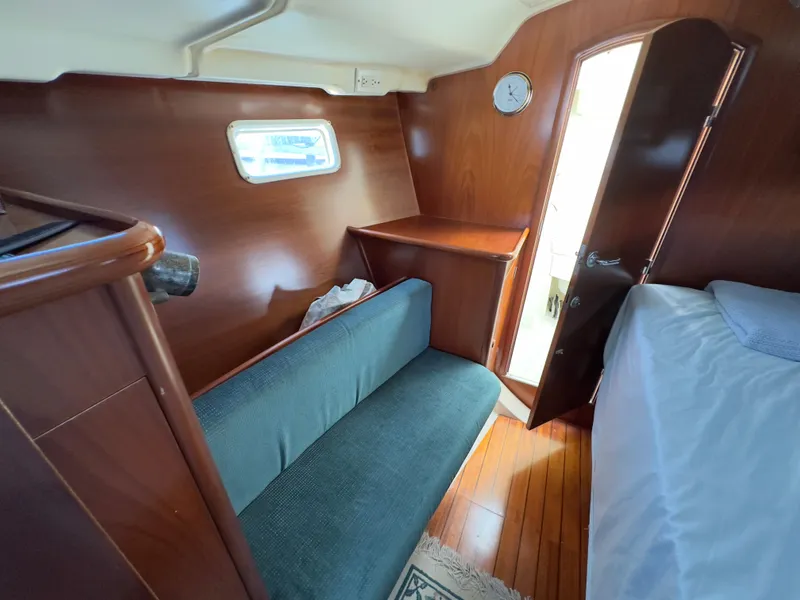 Slide: The Image of Interior of 2000 Beneteau 411 sailboat with wooden finish and cozy seating area. - 45