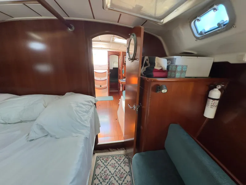 Slide: The Image of Cozy cabin interior of 2000 Beneteau 411 sailboat with wooden finish and comfortable bedding. - 46