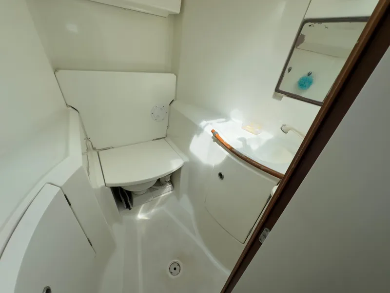 Slide: The Image of Beneteau 411 (2000) yacht bathroom with compact design, white fixtures, and mirror. - 47