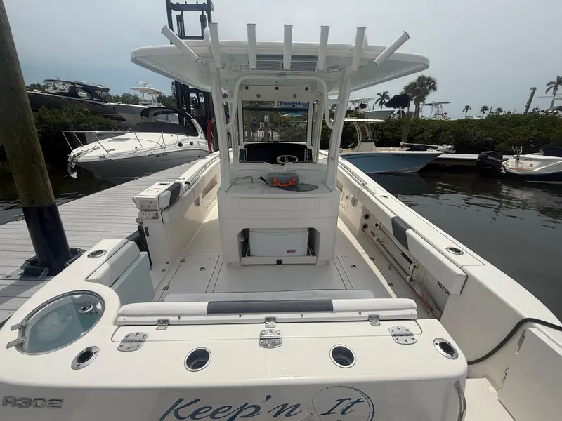 Slide: The Image of 2019 Robalo R302 Center Console boat docked, featuring spacious deck and fishing amenities. - 10