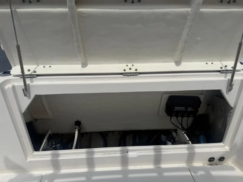 Slide: The Image of 2019 Robalo R302 Center Console storage compartment with open hatch, showcasing internal components. - 11
