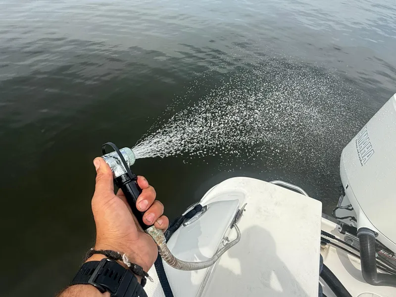 Slide: The Image of Hand spraying water from a 2019 Robalo R302 Center Console boat. - 18
