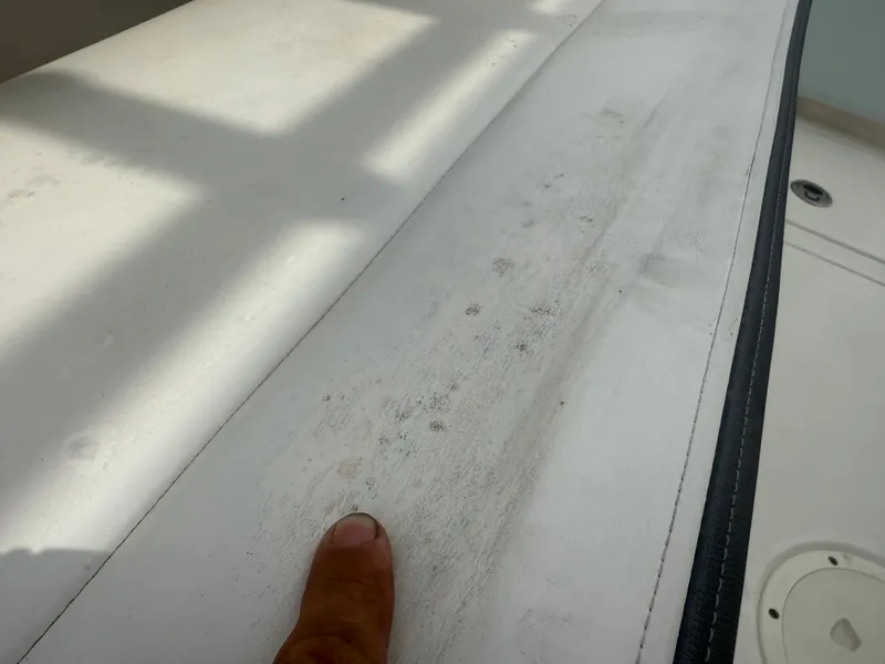 Slide: The Image of 2019 Robalo R302 Center Console boat with a finger pointing at a dirty surface. - 20