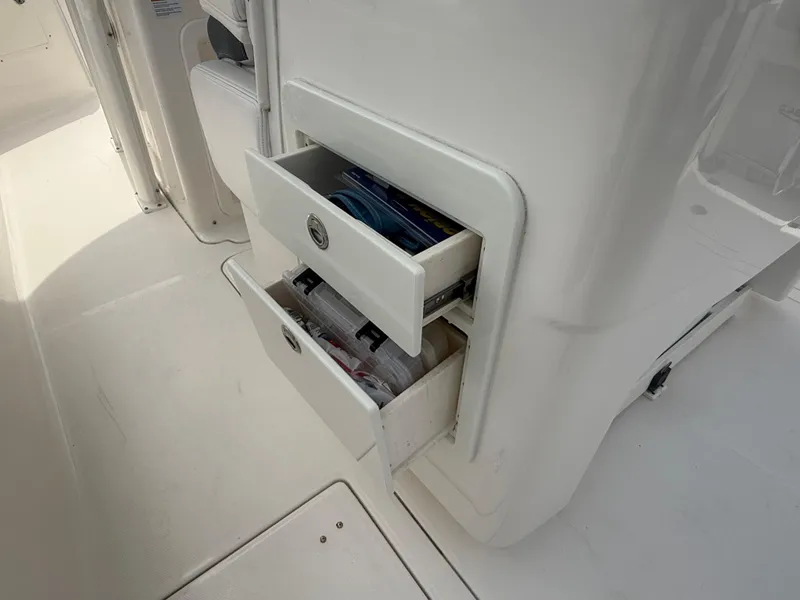 Slide: The Image of 2019 Robalo R302 Center Console boat with open storage drawers. - 27