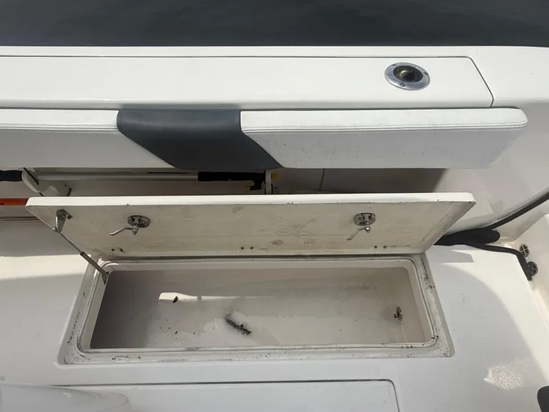 Slide: The Image of 2019 Robalo R302 Center Console storage compartment, open and empty, with white interior. - 29