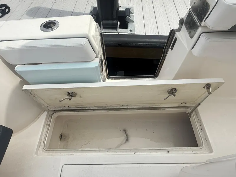 Slide: The Image of 2019 Robalo R302 Center Console storage compartment with open hatch on deck. - 30