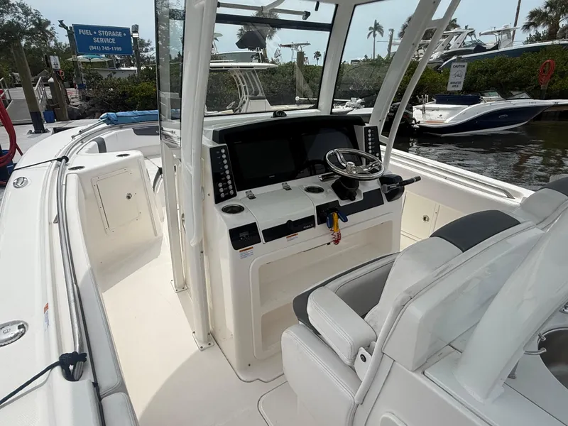 Slide: The Image of 2019 Robalo R302 Center Console boat interior with steering wheel and navigation controls. - 31