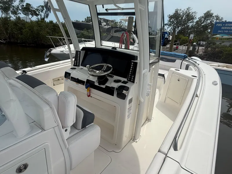 Slide: The Image of 2019 Robalo R302 Center Console boat interior with steering wheel and navigation equipment. - 32