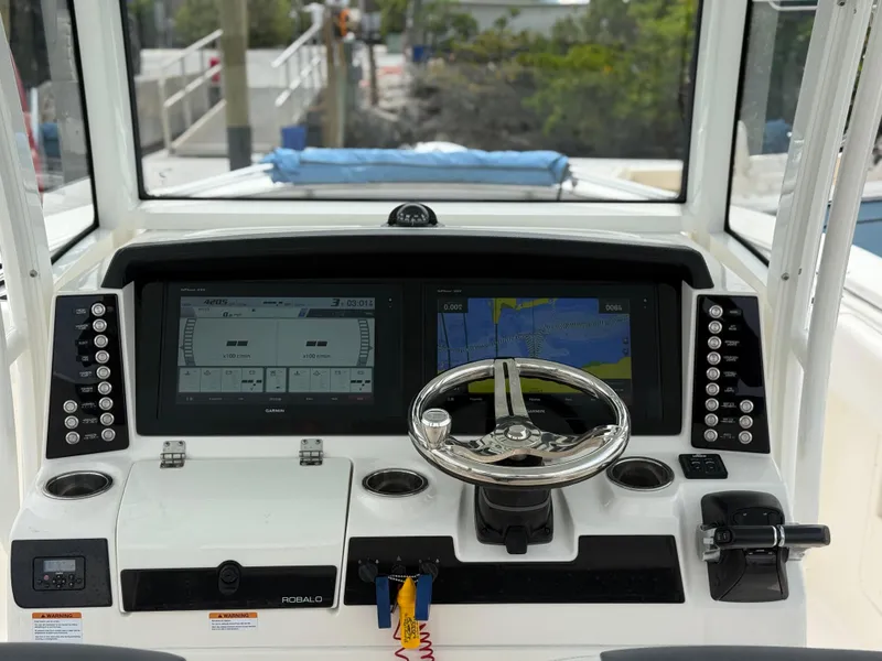 Slide: The Image of 2019 Robalo R302 Center Console helm with dual displays and steering wheel. - 36