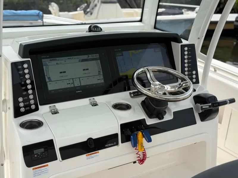 Slide: The Image of 2019 Robalo R302 Center Console helm with dual displays and steering wheel. - 37