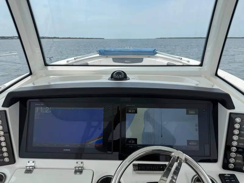 Slide: The Image of 2019 Robalo R302 Center Console helm with dual navigation screens on open water. - 38
