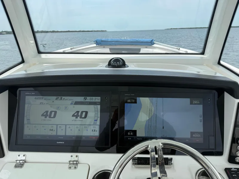 Slide: The Image of 2019 Robalo R302 Center Console dashboard with dual navigation screens on open water. - 39
