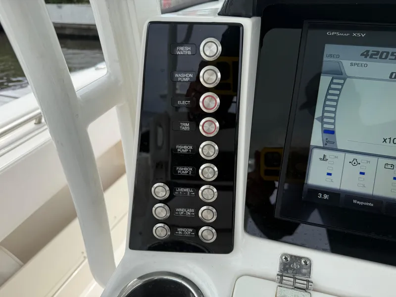Slide: The Image of Control panel of a 2019 Robalo R302 Center Console boat with various switches. - 40