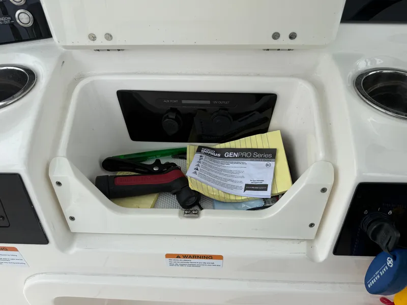 Slide: The Image of Storage compartment on a 2019 Robalo R302 Center Console boat with tools and manuals. - 45