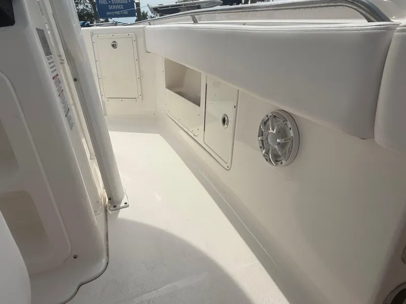 Slide: The Image of 2019 Robalo R302 Center Console boat interior with storage compartments and speaker. - 47