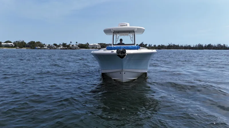 Slide: The Image of 2019 Robalo R302 Center Console boat on calm water, clear sky background. - 5
