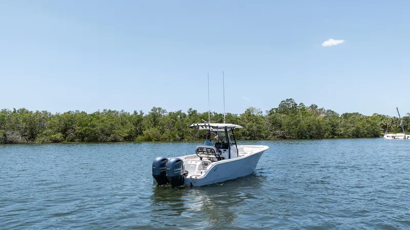Slide: The Image of 2022 Sea Fox 268 Commander boat on calm water near lush shoreline. - 10