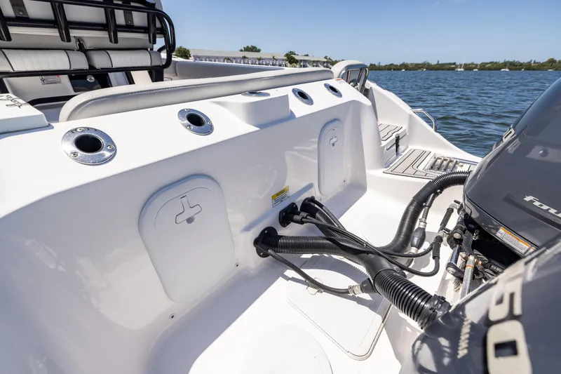 Slide: The Image of 2022 Sea Fox 268 Commander boat with engine and fishing rod holders on a sunny day. - 21