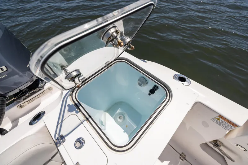 Slide: The Image of 2022 Sea Fox 268 Commander livewell on deck, open lid, near water. - 24