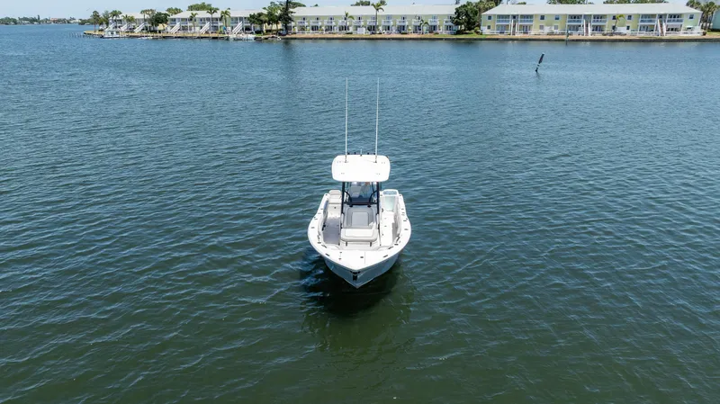 Slide: The Image of 2022 Sea Fox 268 Commander boat on calm water, with shoreline in the background. - 3