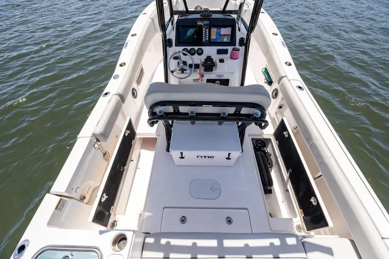 Slide: The Image of 2022 Sea Fox 268 Commander boat interior with helm, seating, and storage, on water. - 32