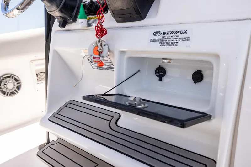 Slide: The Image of 2022 Sea Fox 268 Commander dashboard with controls and storage compartment. - 48