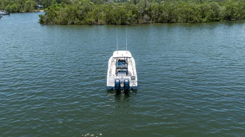 Slide: The Image of 2022 Sea Fox 268 Commander boat on calm water near lush green shoreline. - 7
