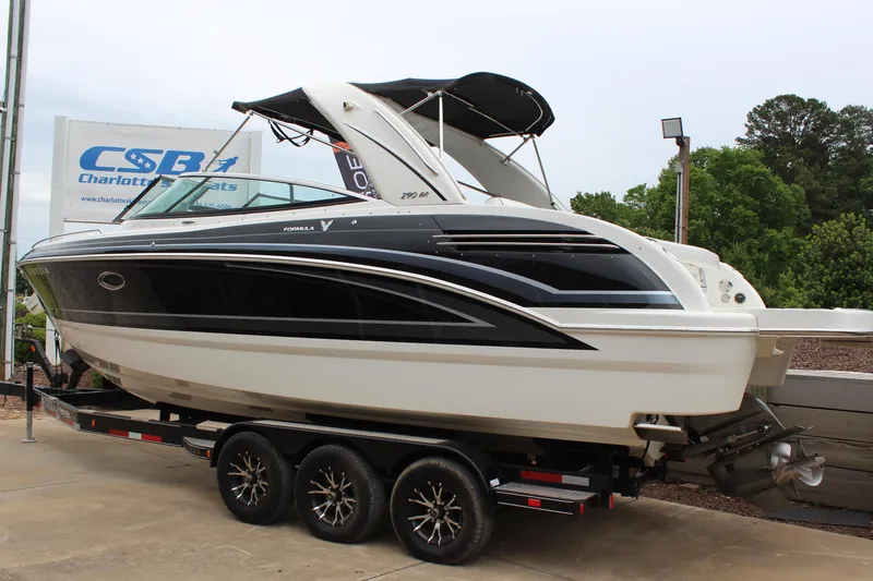 Slide: The Image of 2021 Formula 290 Bowrider boat on trailer, black and white design, parked outdoors. - 3