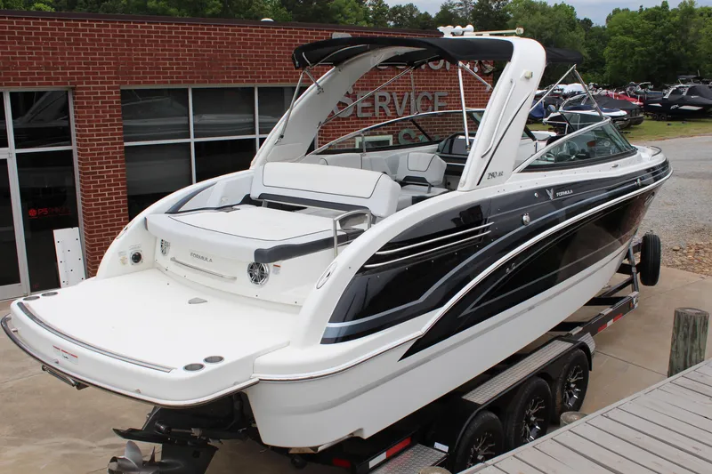 Slide: The Image of 2021 Formula 290 Bowrider boat on trailer, parked near a brick building. - 5