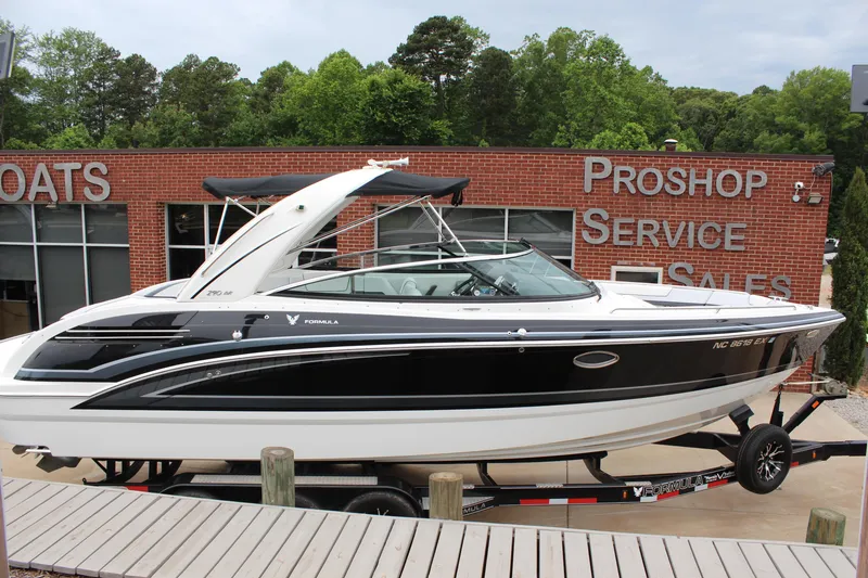 Slide: The Image of 2021 Formula 290 Bowrider boat displayed at a dealership with service and sales signage. - 6