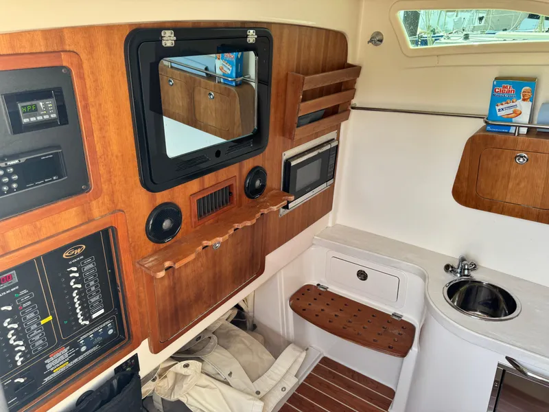 Slide: The Image of 2017 Grady-White Canyon 376 cabin interior with wood paneling, sink, and control panels. - 16