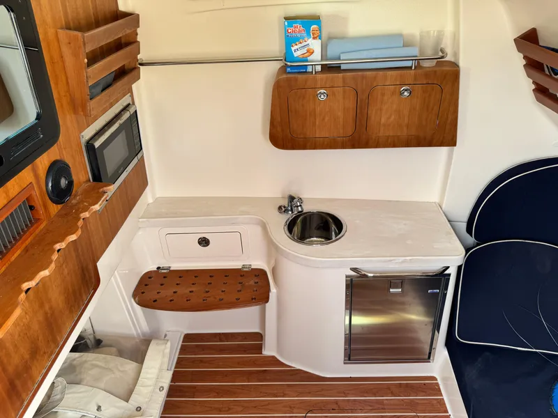 Slide: The Image of 2017 Grady-White Canyon 376 boat interior with kitchenette, sink, and wooden cabinetry. - 18