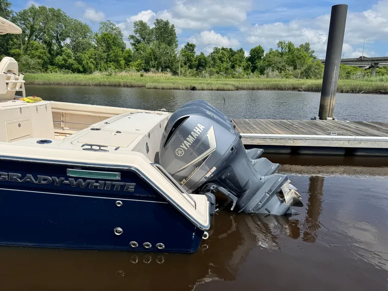 Slide: The Image of 2017 Grady-White Canyon 376 boat with Yamaha engine docked by a river. - 2
