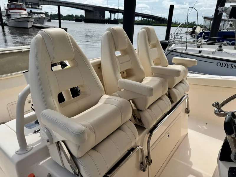 Slide: The Image of 2017 Grady-White Canyon 376 boat with three luxurious white seats, docked near a bridge. - 20