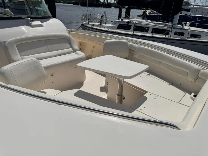Slide: The Image of 2017 Grady-White Canyon 376 boat interior with seating and table, docked by the water. - 6