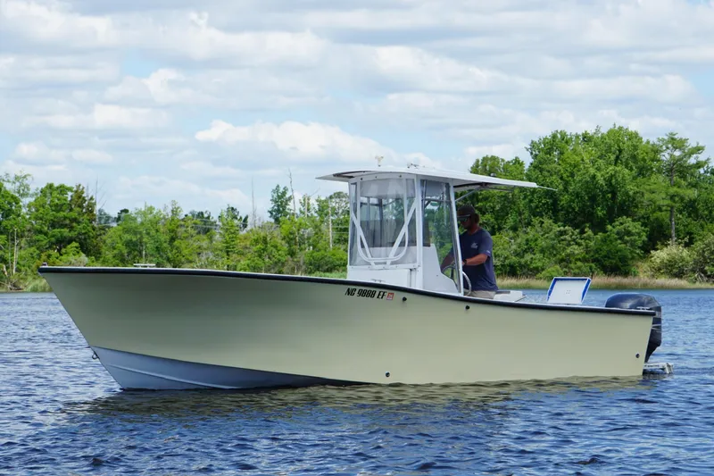 The Image of 1993 KenCraft CHALLENGER 250CC boat on a calm lake with lush green background. - 0